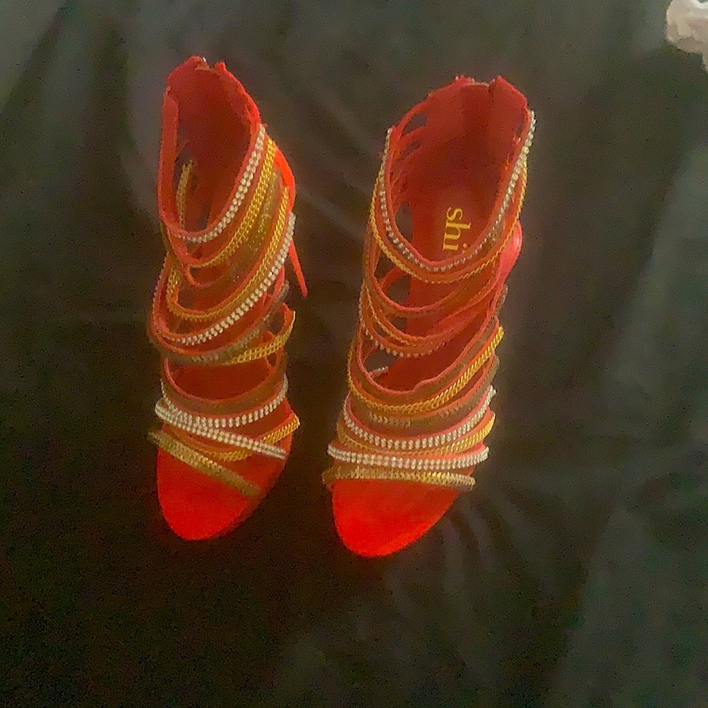 Selling brand new red high heels never been worn with gold and silver straps.